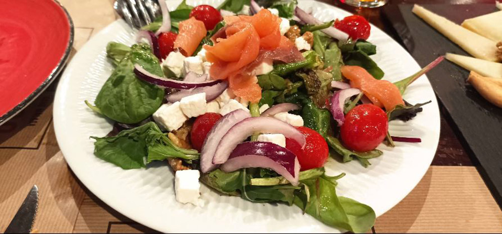 Mixed Greens Salad with smoked salmon, capers, red onion, cherry tomatoes, and tartar sauce.